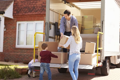family unpacking boxes from moving truck
