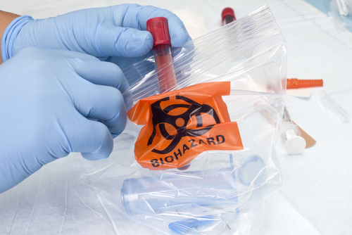 nurse places test tube biohazard bag