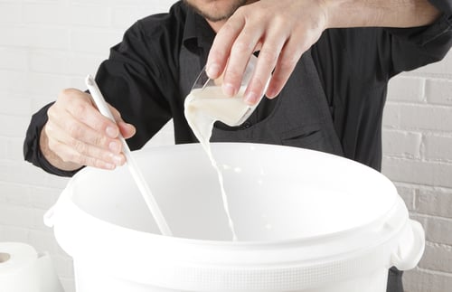 Homebrewer making beer adding yeast