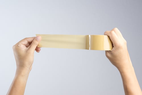 hand holding brown packing tape