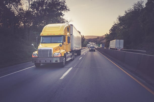 Yellow 18 wheeler truck on highway