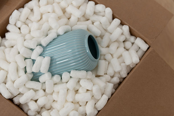 A blue ceramic vase packed in packing peanuts