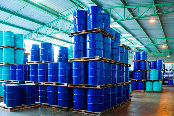 a warehouse with stacks of oil drums